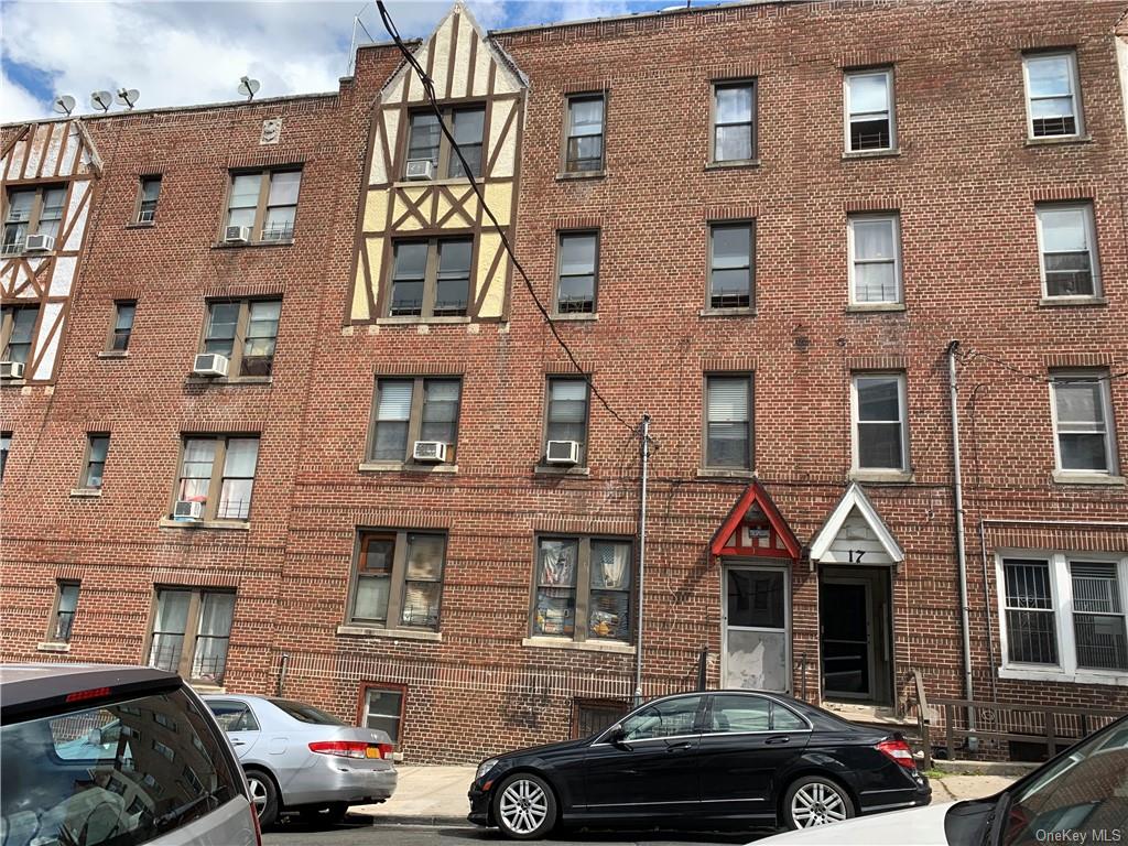 a front view of a building and car parked