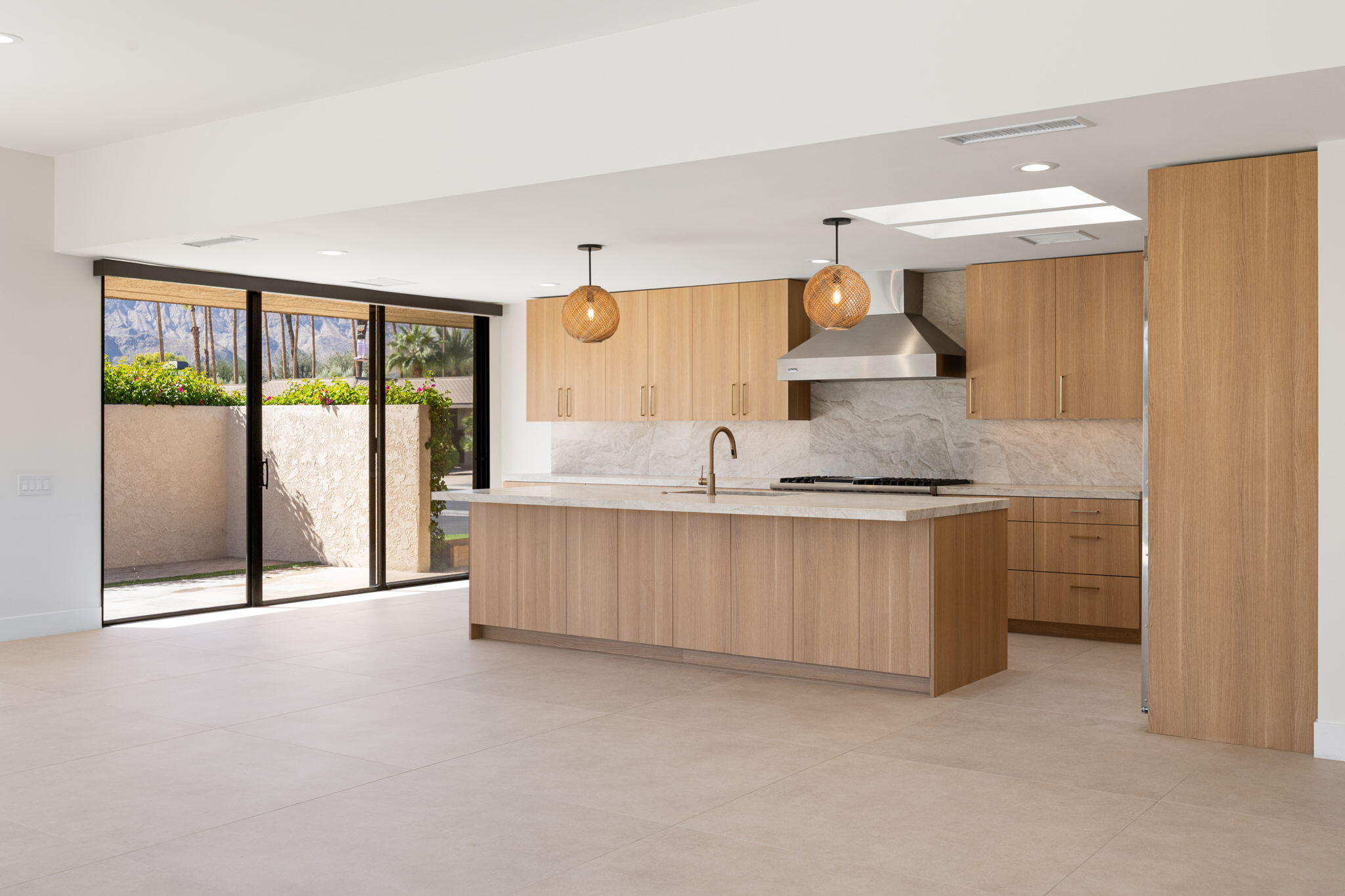 a large white kitchen with stainless steel appliances granite countertop a stove and a sink