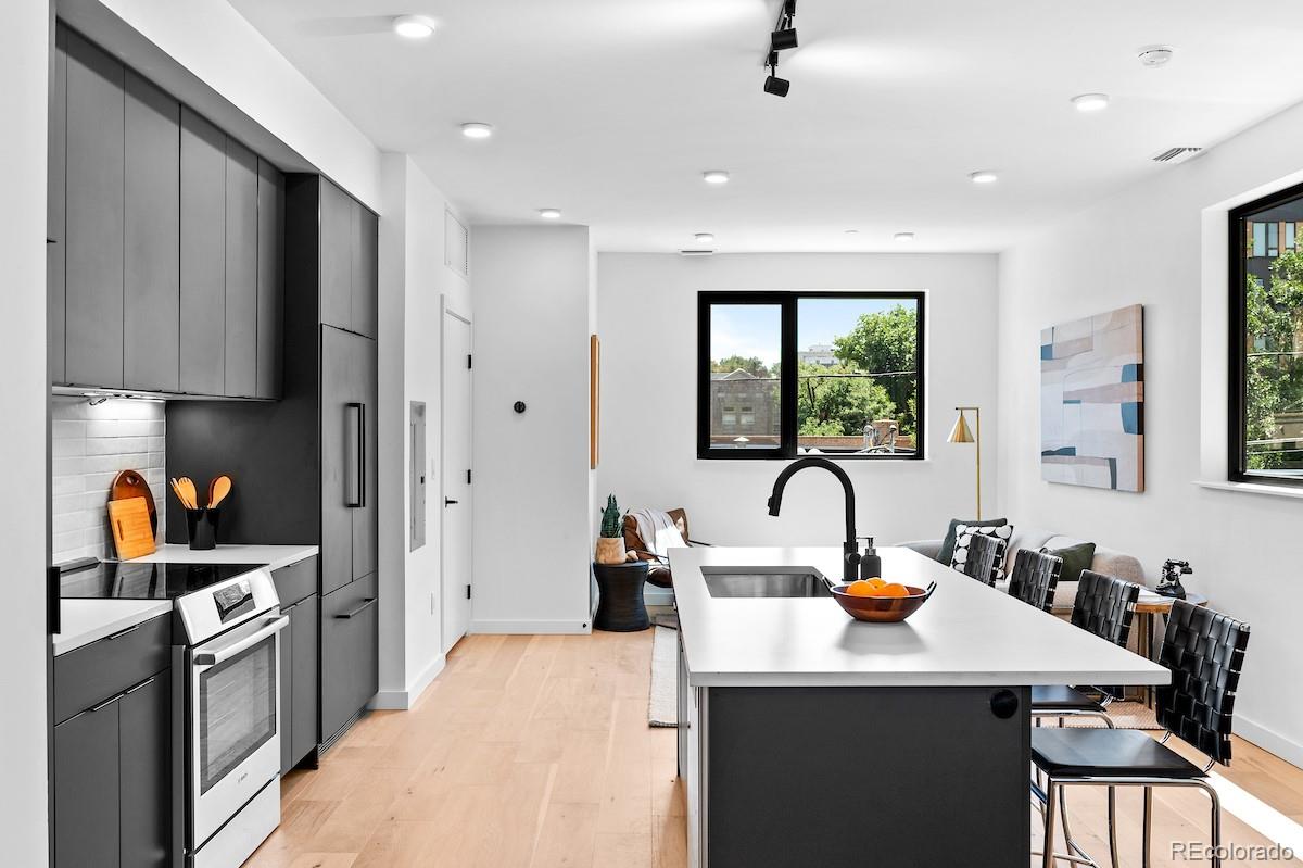 a kitchen that has a lot of cabinets a sink and a refrigerator