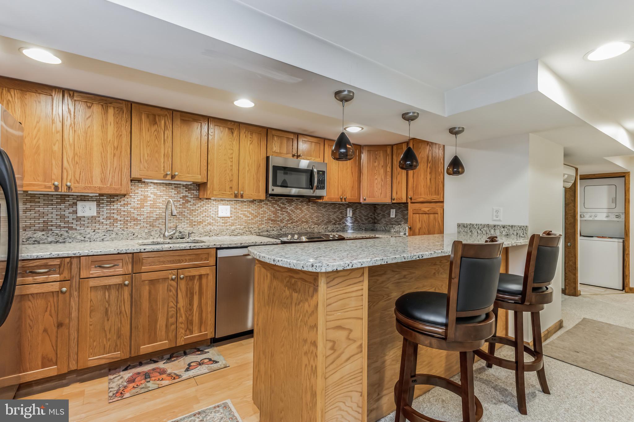 a kitchen with kitchen island granite countertop wooden cabinets and a granite counter tops