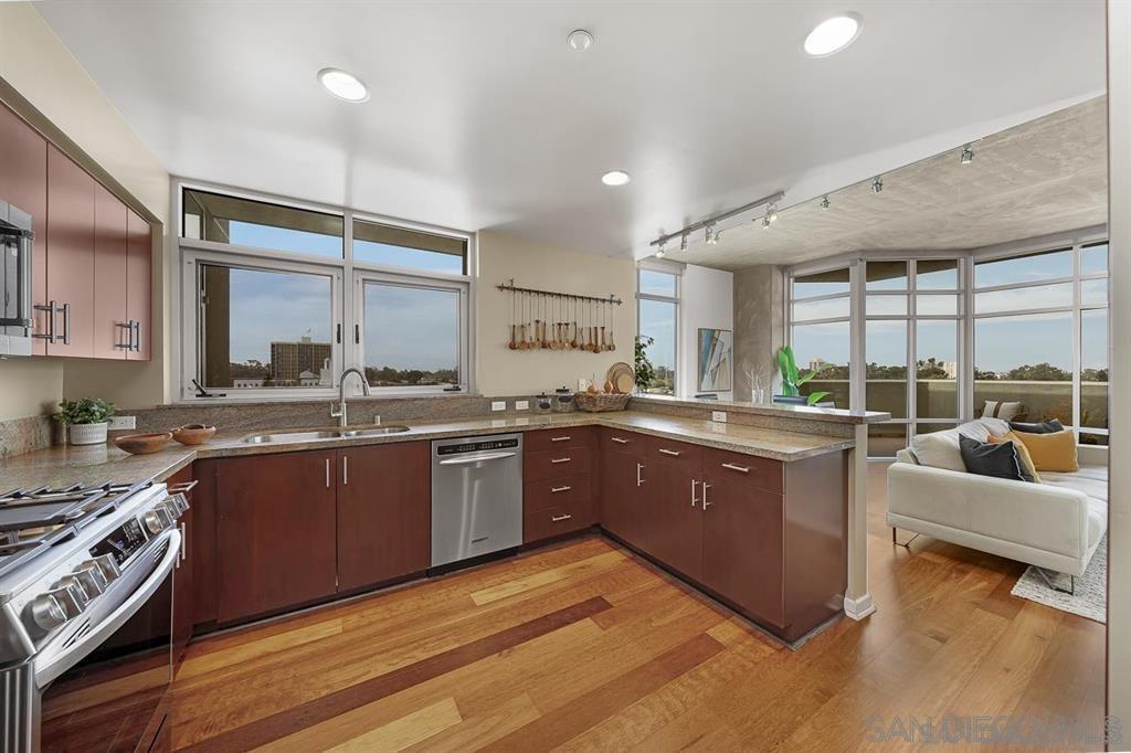 a large kitchen with stainless steel appliances granite countertop a lot of counter space and a sink