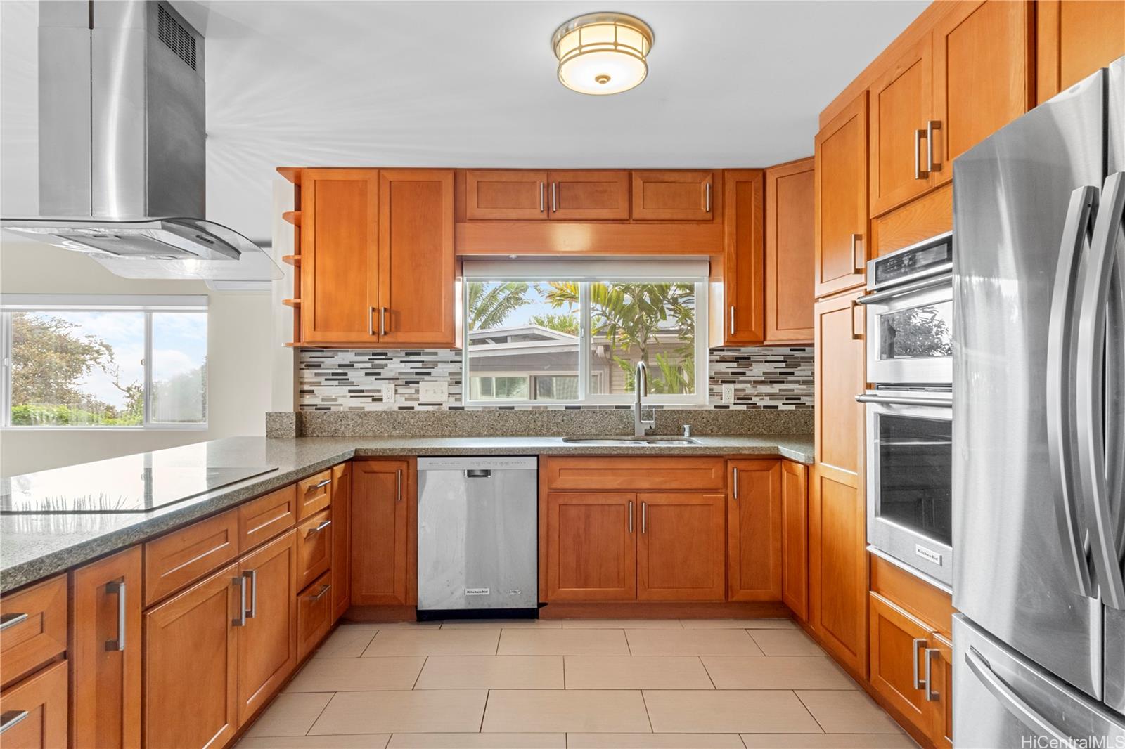 a large kitchen with stainless steel appliances granite countertop a refrigerator and a sink