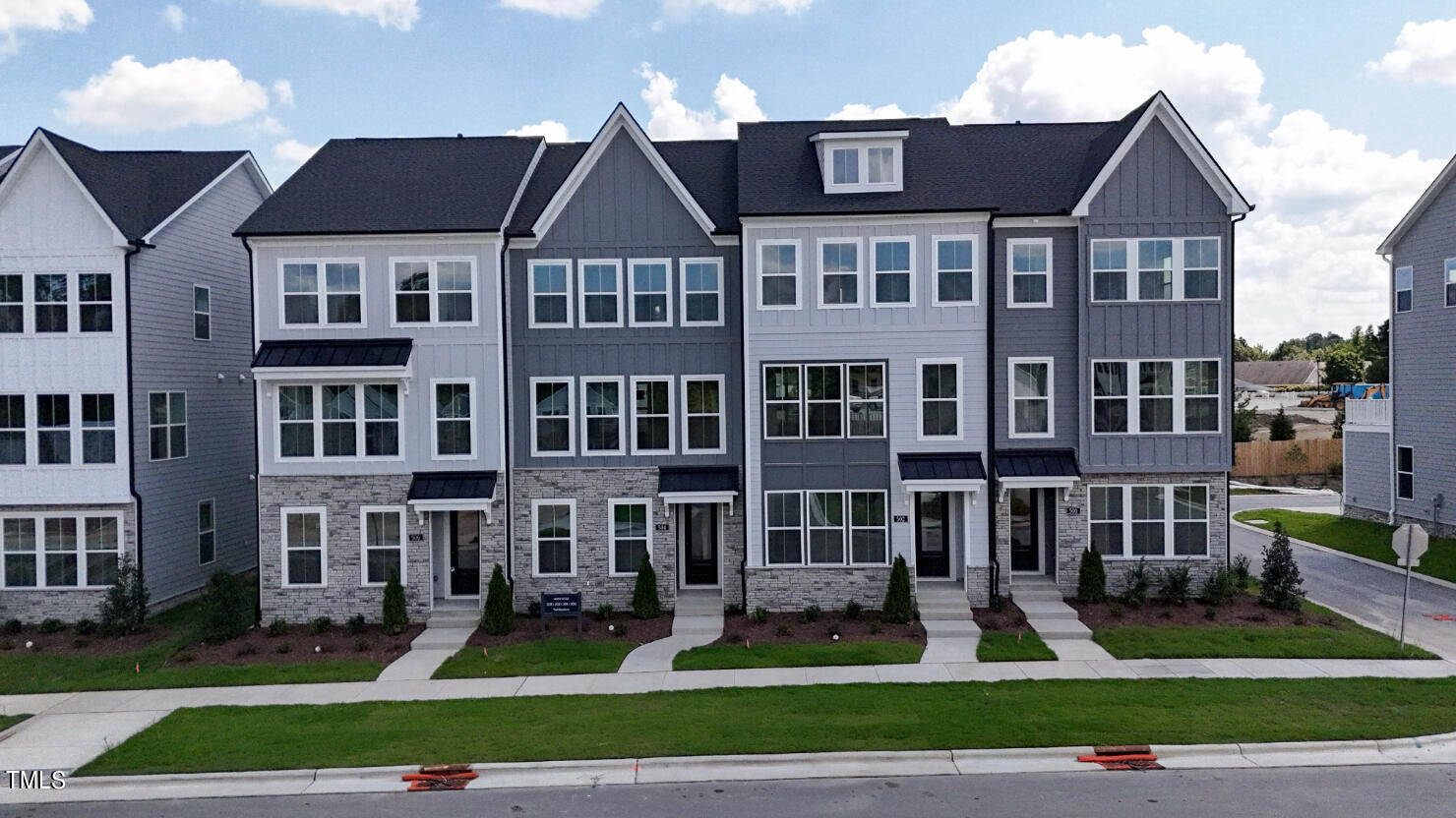 a front view of residential houses with yard and green space