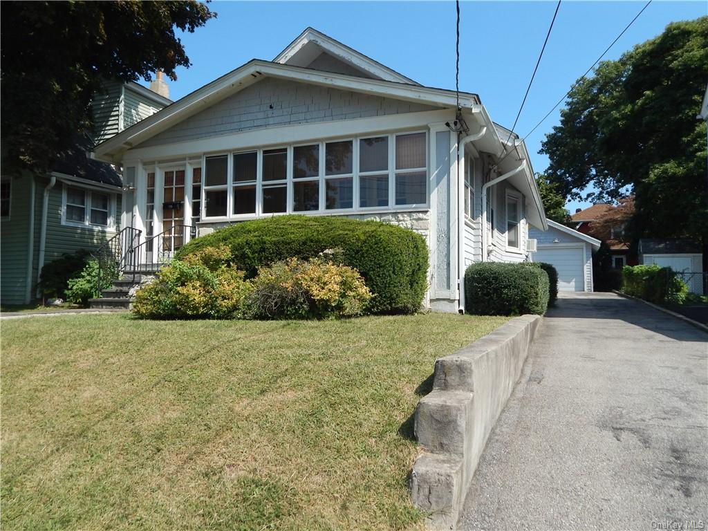 1930's Bungalow-style house with a garage and a front yard