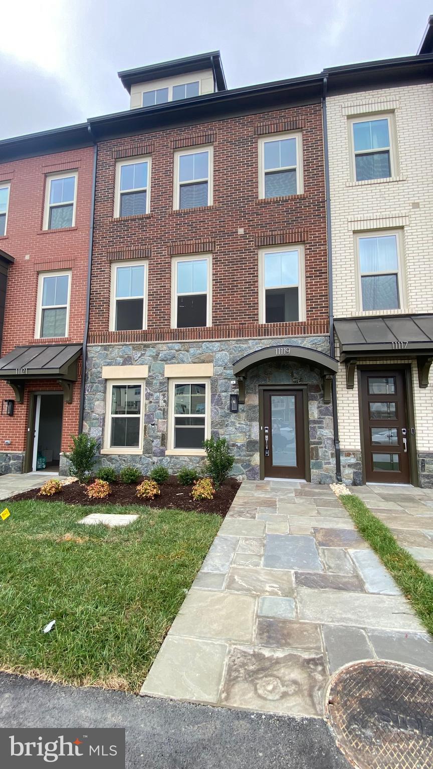 a front view of a brick building with yard