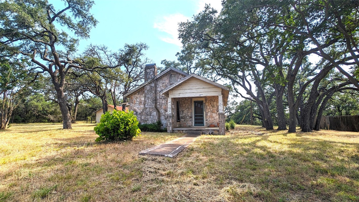 a large tree in front of a house with a yard