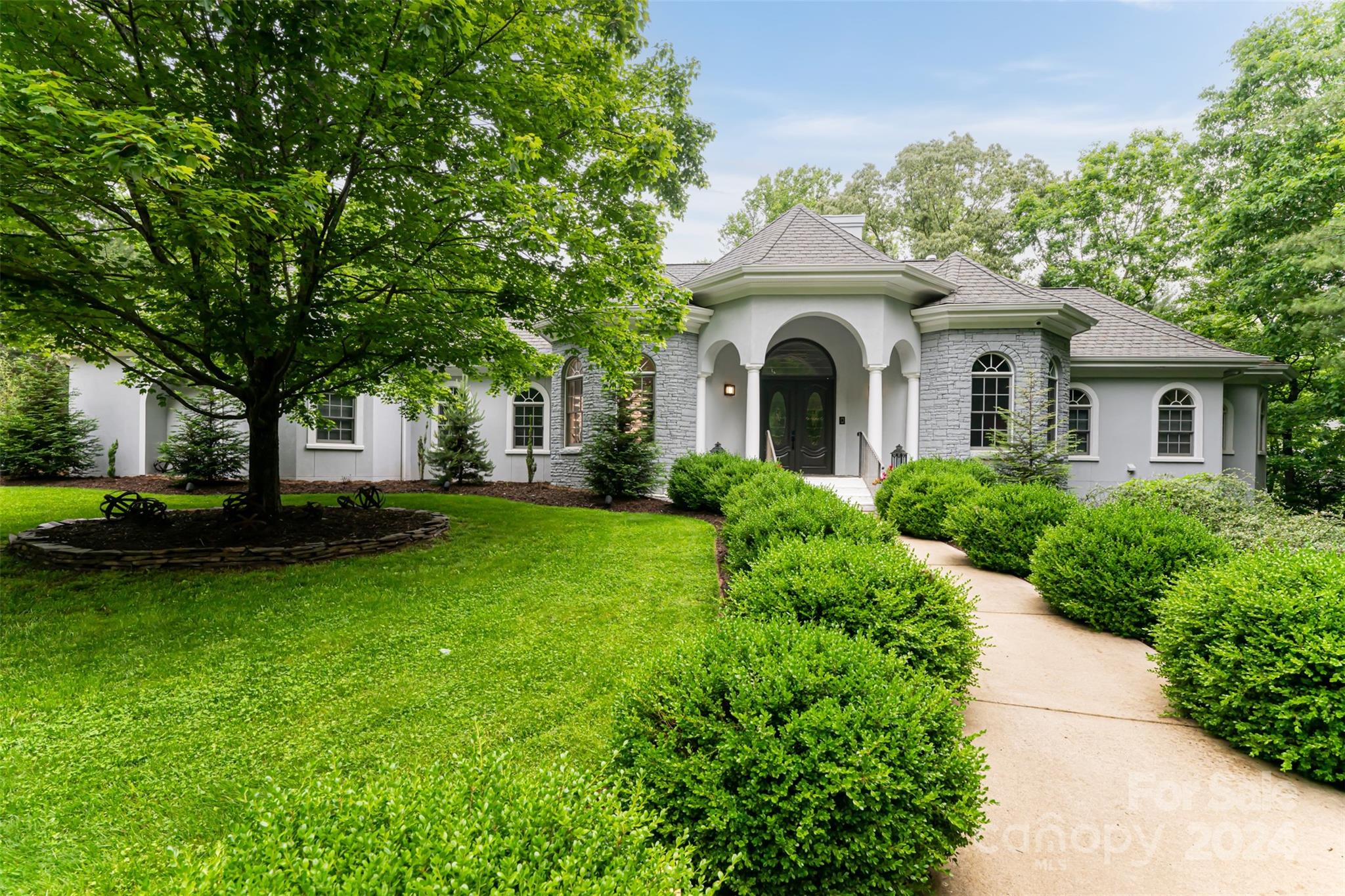 a front view of a house with a garden