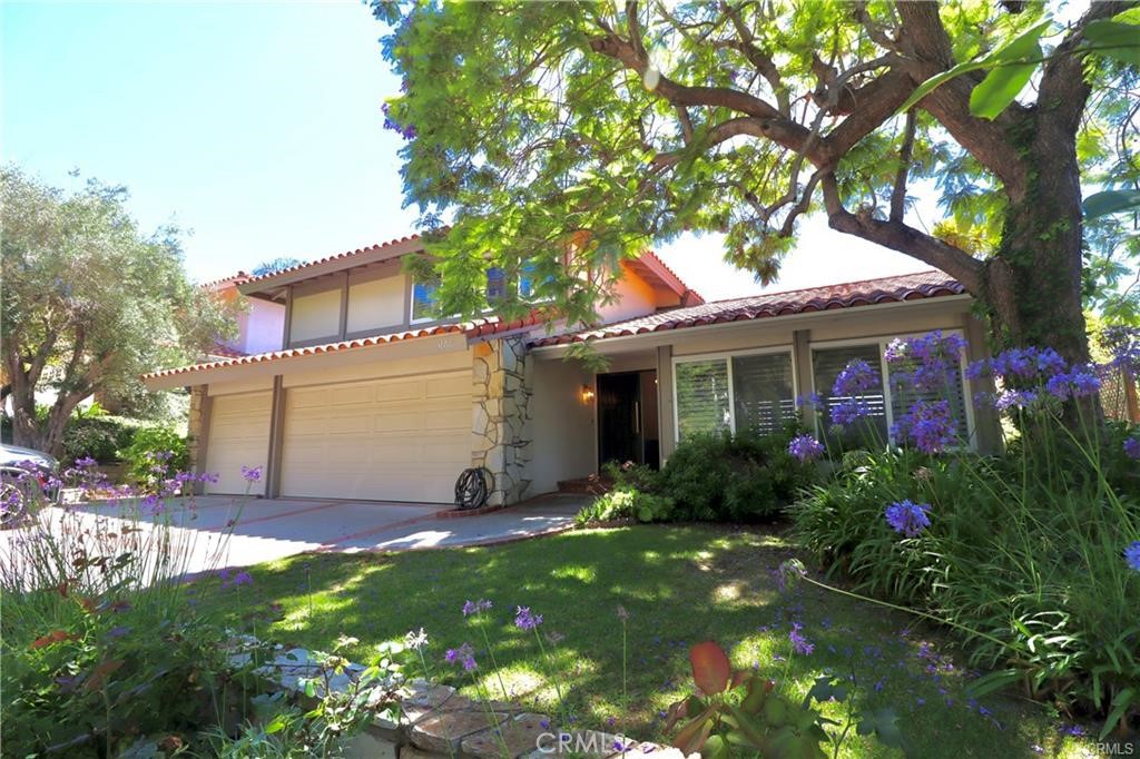 a view of a house with brick walls and a flower garden