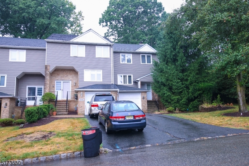 a front view of a house with cars parked