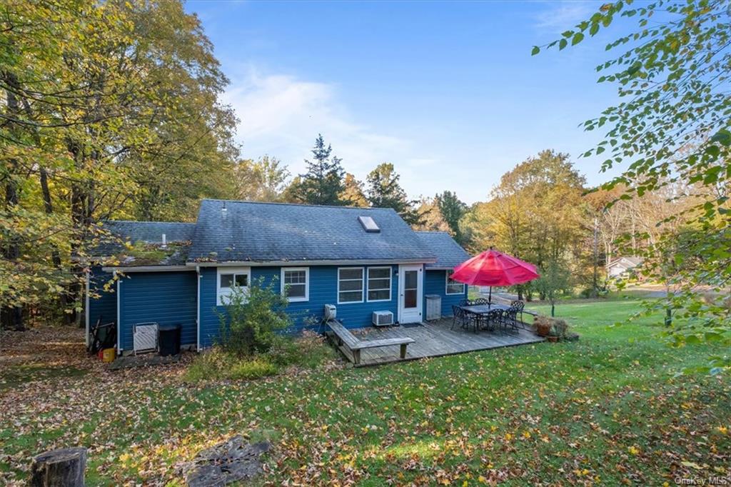 a view of house with a backyard and a tree