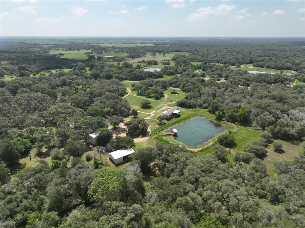 an aerial view of residential houses with outdoor space and trees