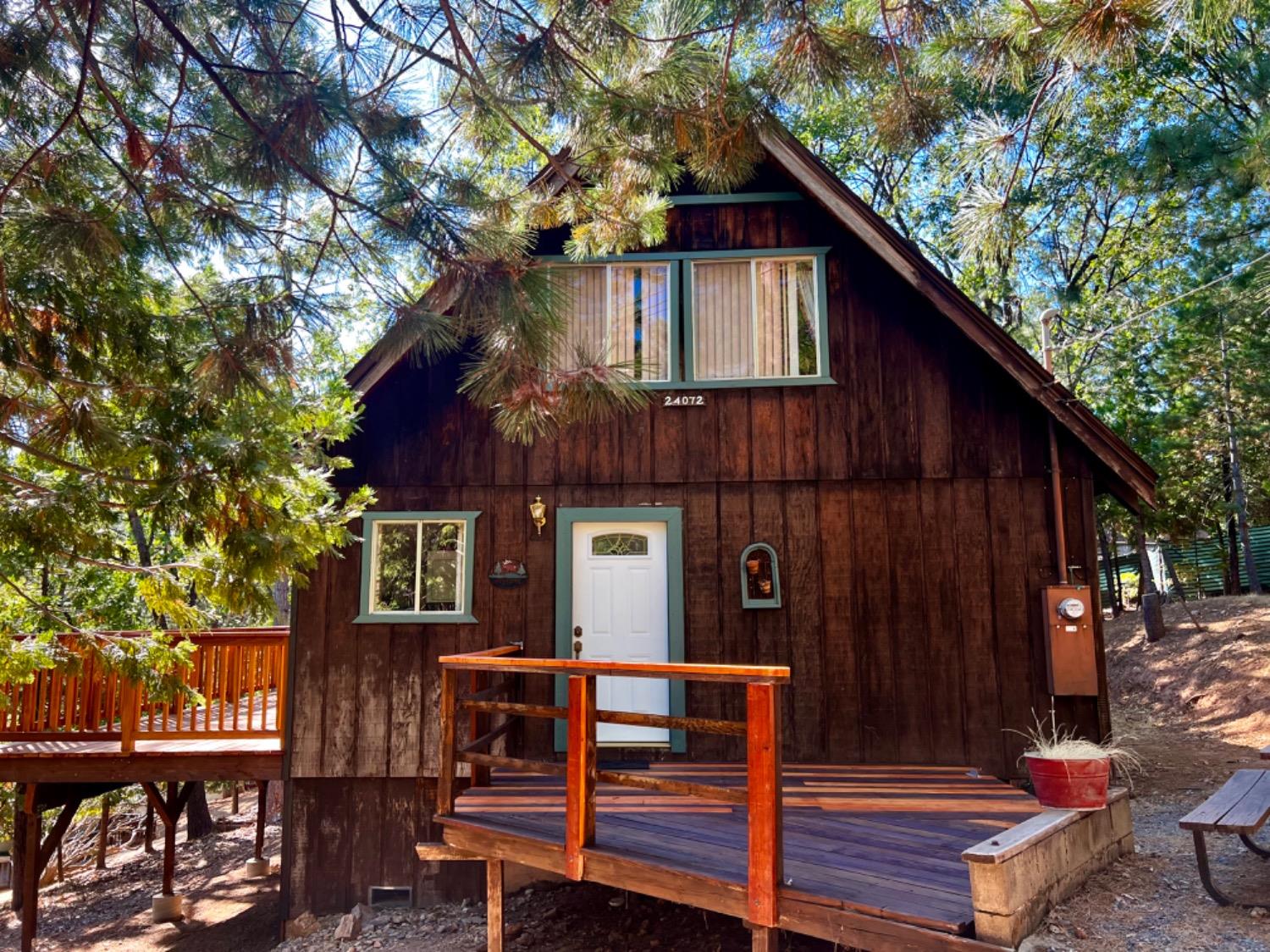 a view of backyard with a deck and wooden fence