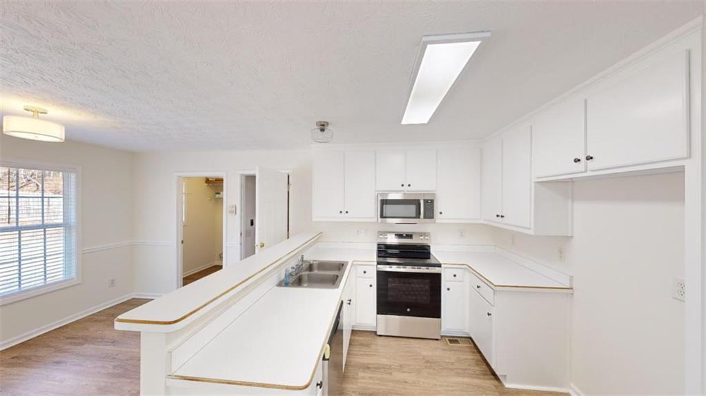 a kitchen with white cabinets and appliances