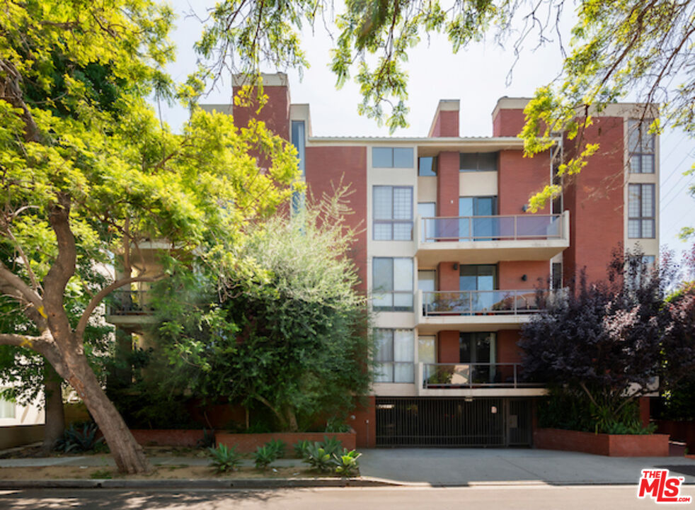 a front view of a multi story residential apartment building with a yard