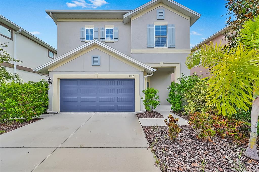 a front view of a house with a yard and garage