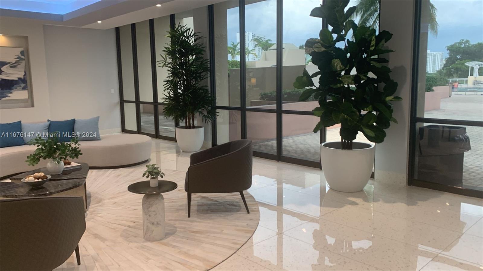 a living room with furniture a potted plant and a large window