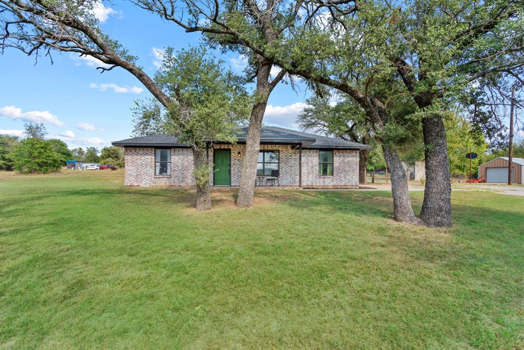 a front view of a house with yard and green space