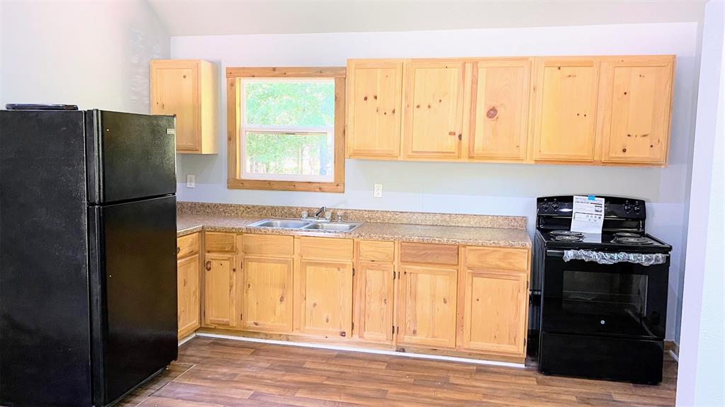 a kitchen with a refrigerator a stove and a window