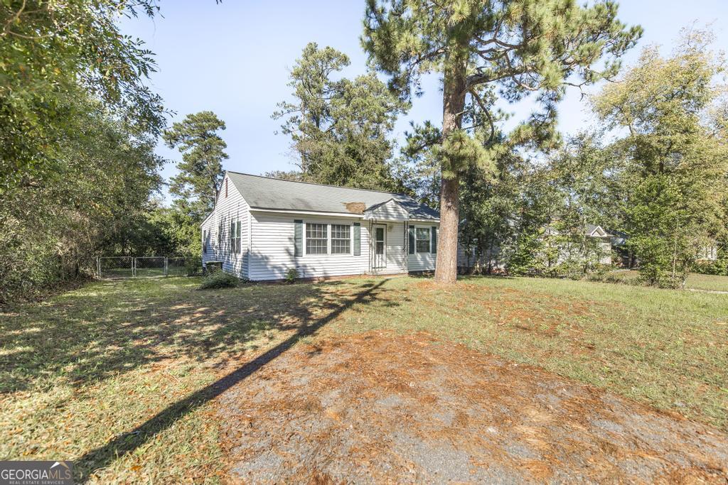 a view of a house with a yard and large tree