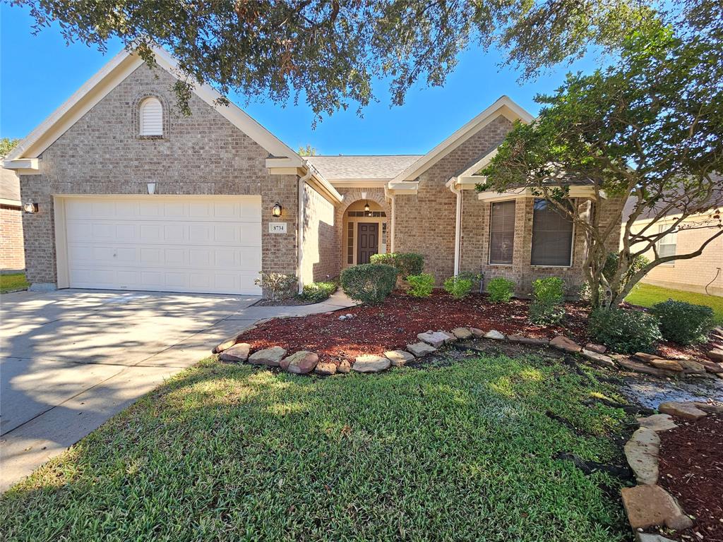 a front view of a house with a garden and yard