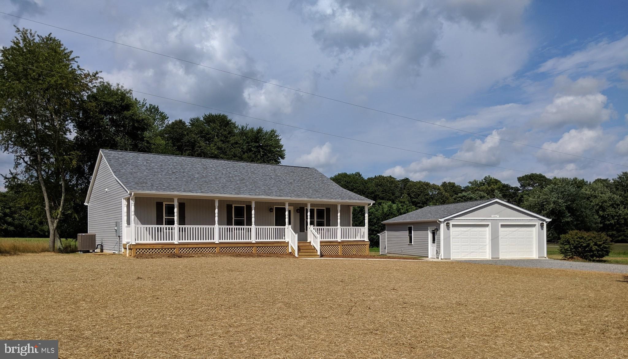 a front view of a house with a garden and yard