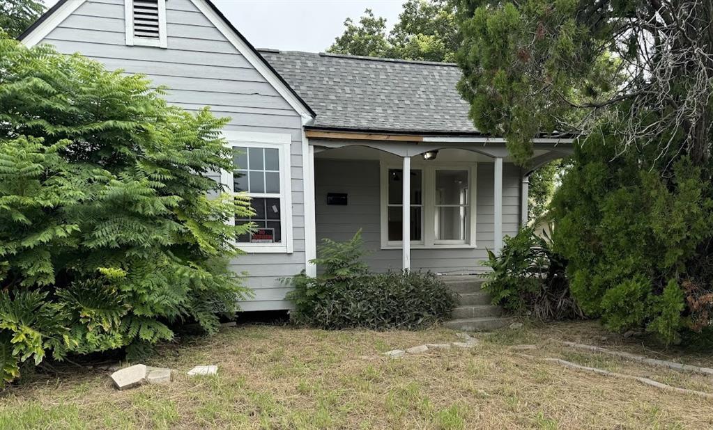 a view of a house with potted plants and large tree