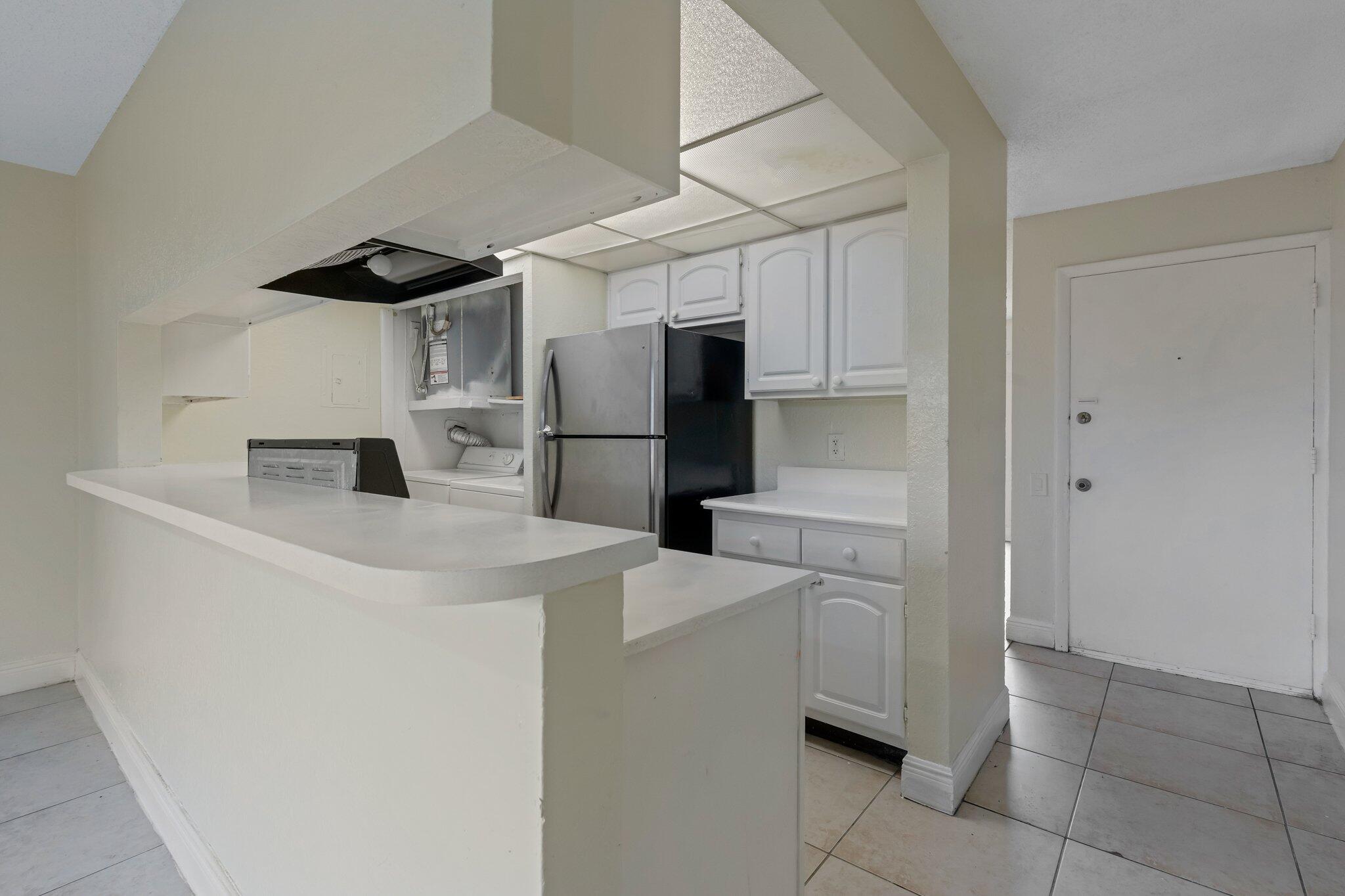 a kitchen with a refrigerator sink and cabinets