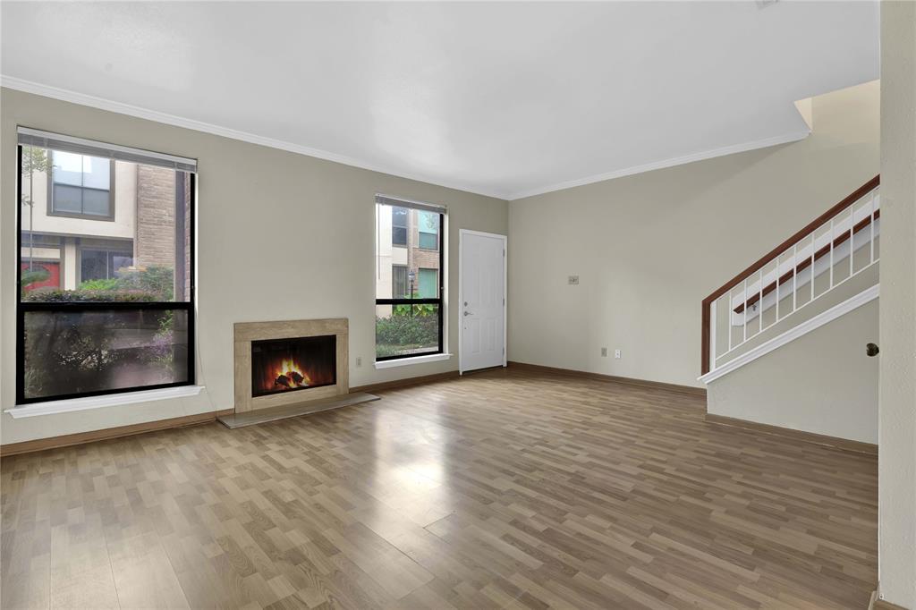 wooden floor fireplace and windows in an empty room