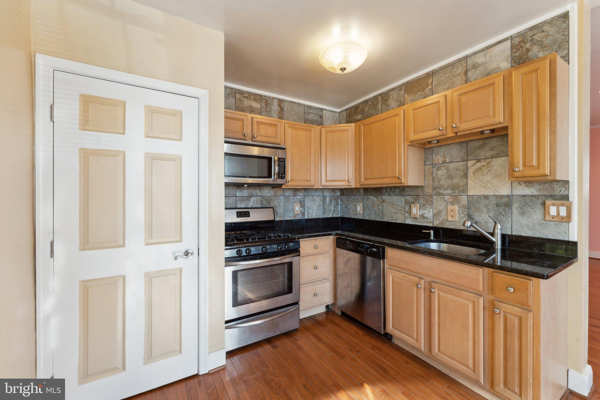 a kitchen with granite countertop white cabinets and appliances