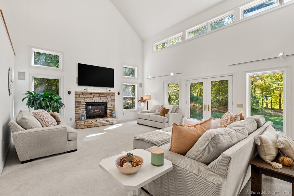 a living room with furniture fireplace and a large window