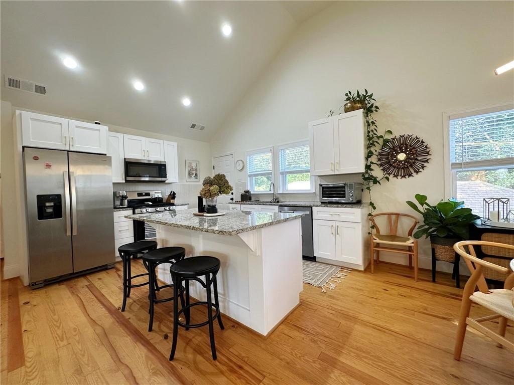 a kitchen with white cabinets and stainless steel appliances