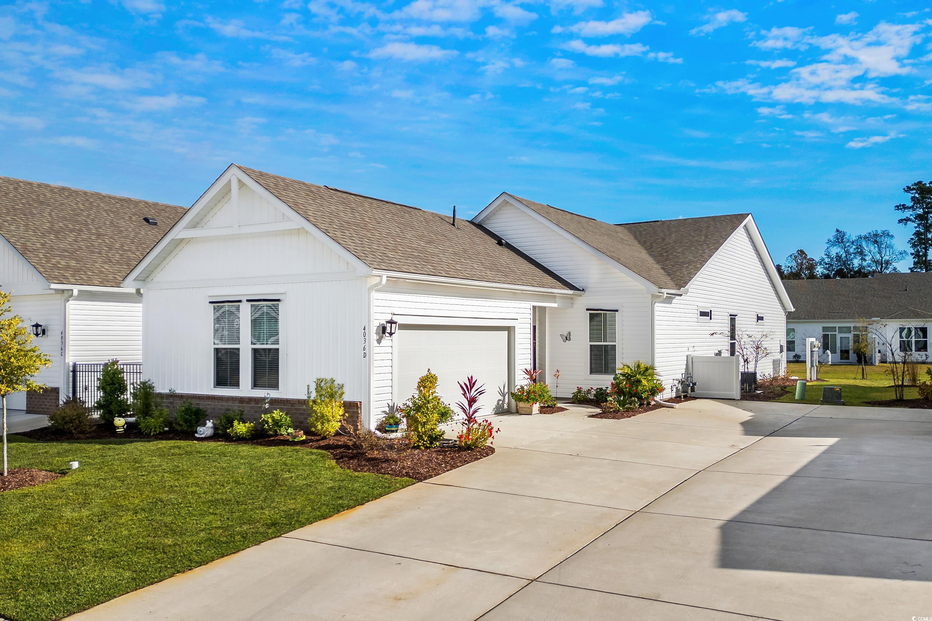 View of front of house with a garage and a front y