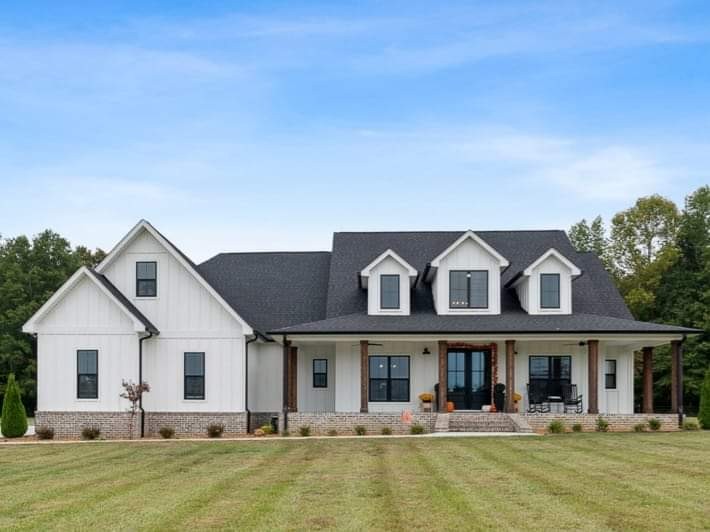 a front view of house with yard and trees in the background