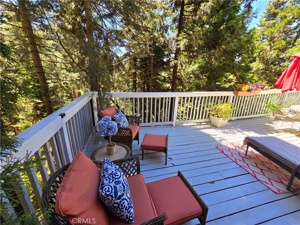 a balcony with wooden floor and outdoor seating