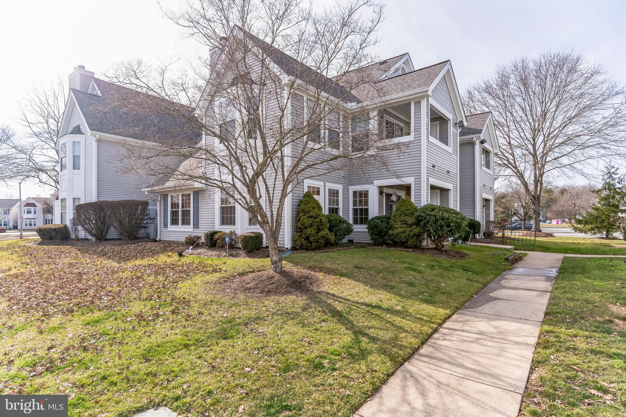 a front view of a house with a yard and trees