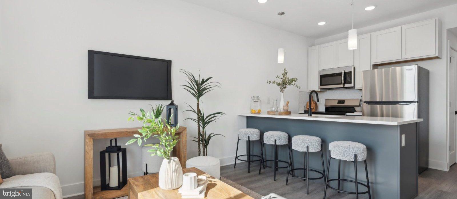 a kitchen with granite countertop stainless steel appliances a table and chairs in it