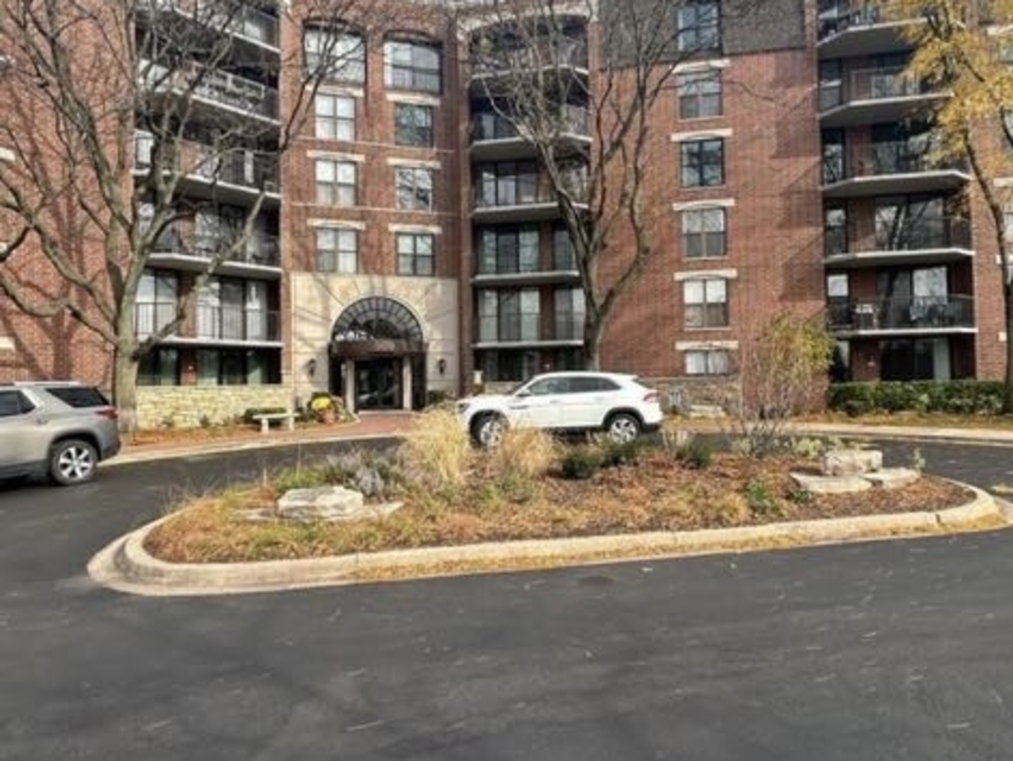 a front view of a building with lot of cars parked