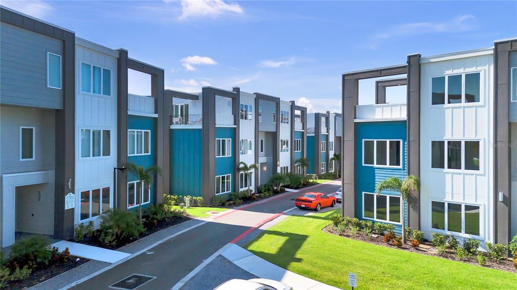 a view of an apartment building with a yard and potted plants