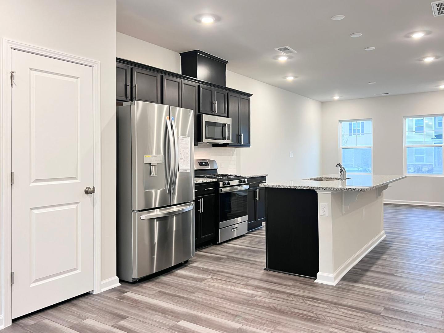 a kitchen with stainless steel appliances granite countertop a refrigerator and a stove top oven