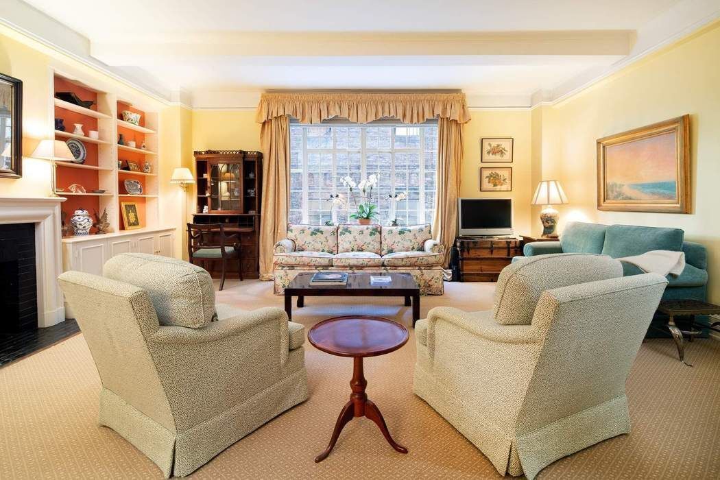 a living room with furniture a rug and a large window