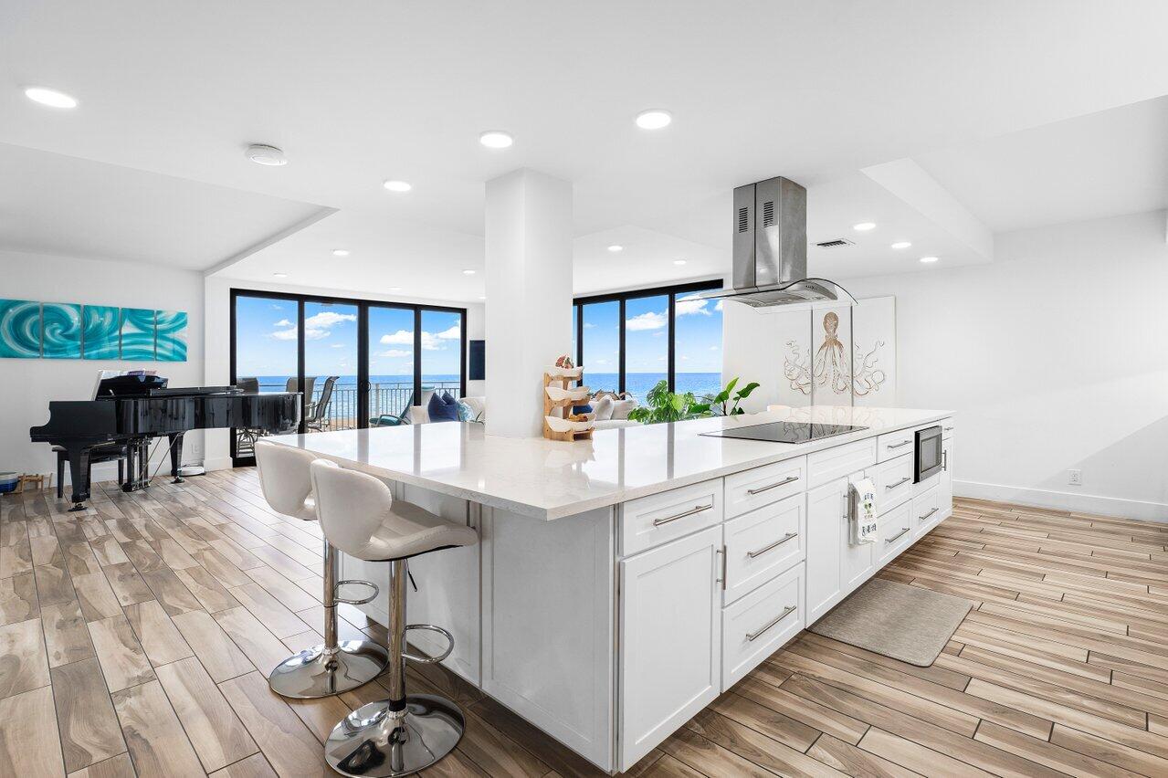 a large white kitchen with lots of counter space and glass door