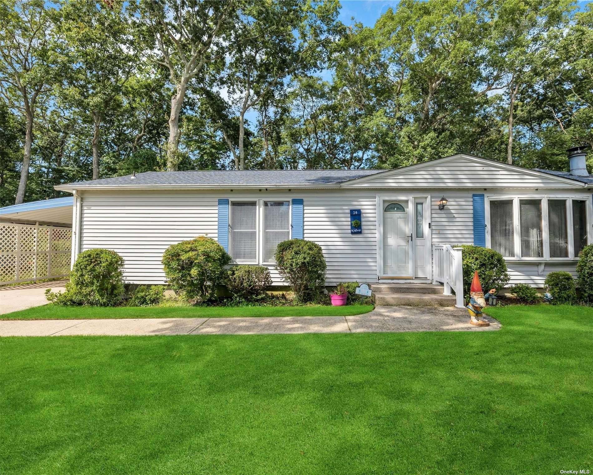 a front view of a house with a yard and trees