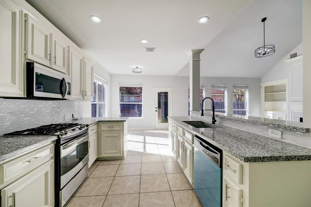 This modern kitchen features granite countertops, stainless steel appliances, and ample natural light. The open layout flows into a spacious living area, ideal for entertaining.