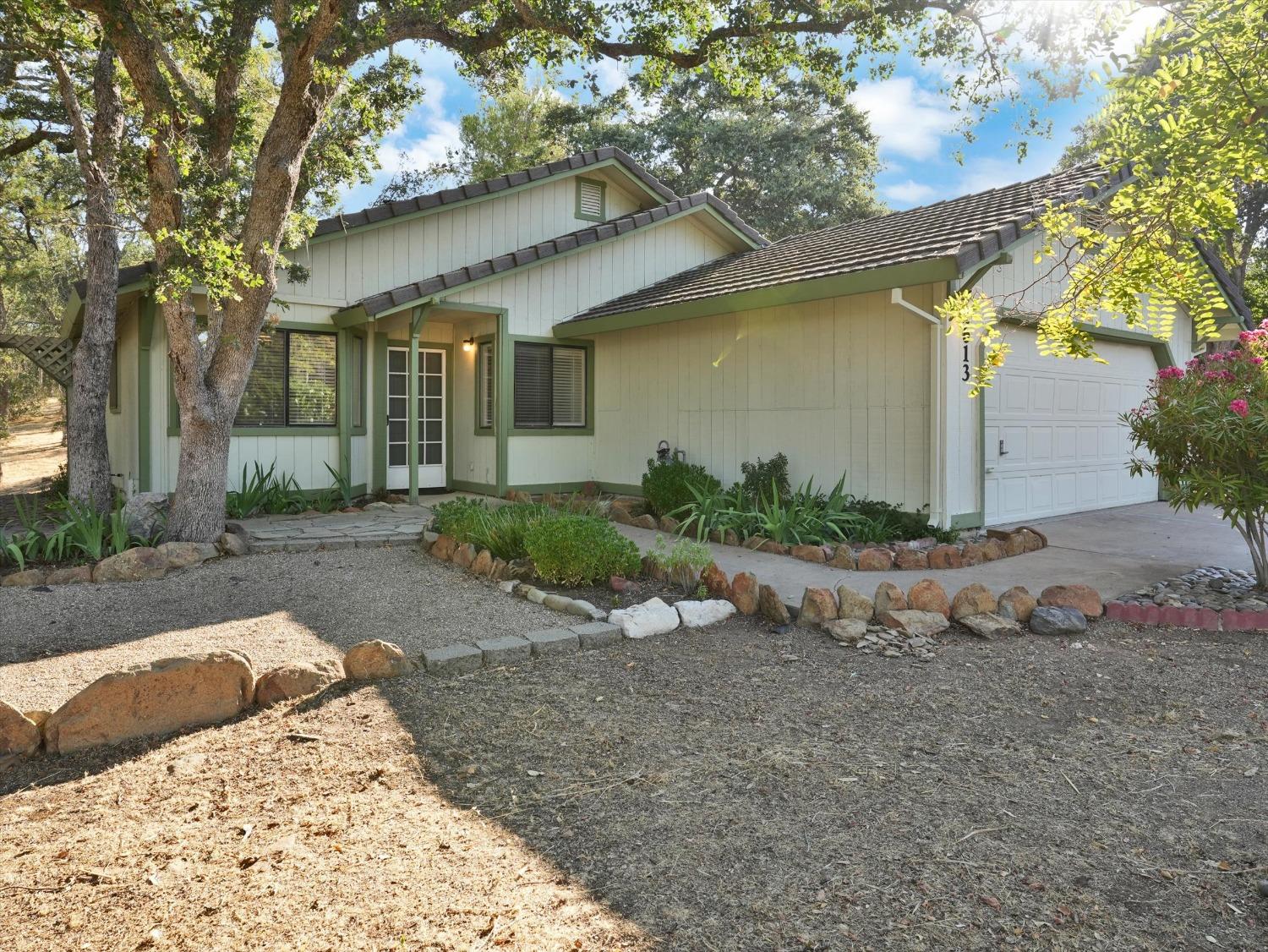 a view of a house with a yard and tree