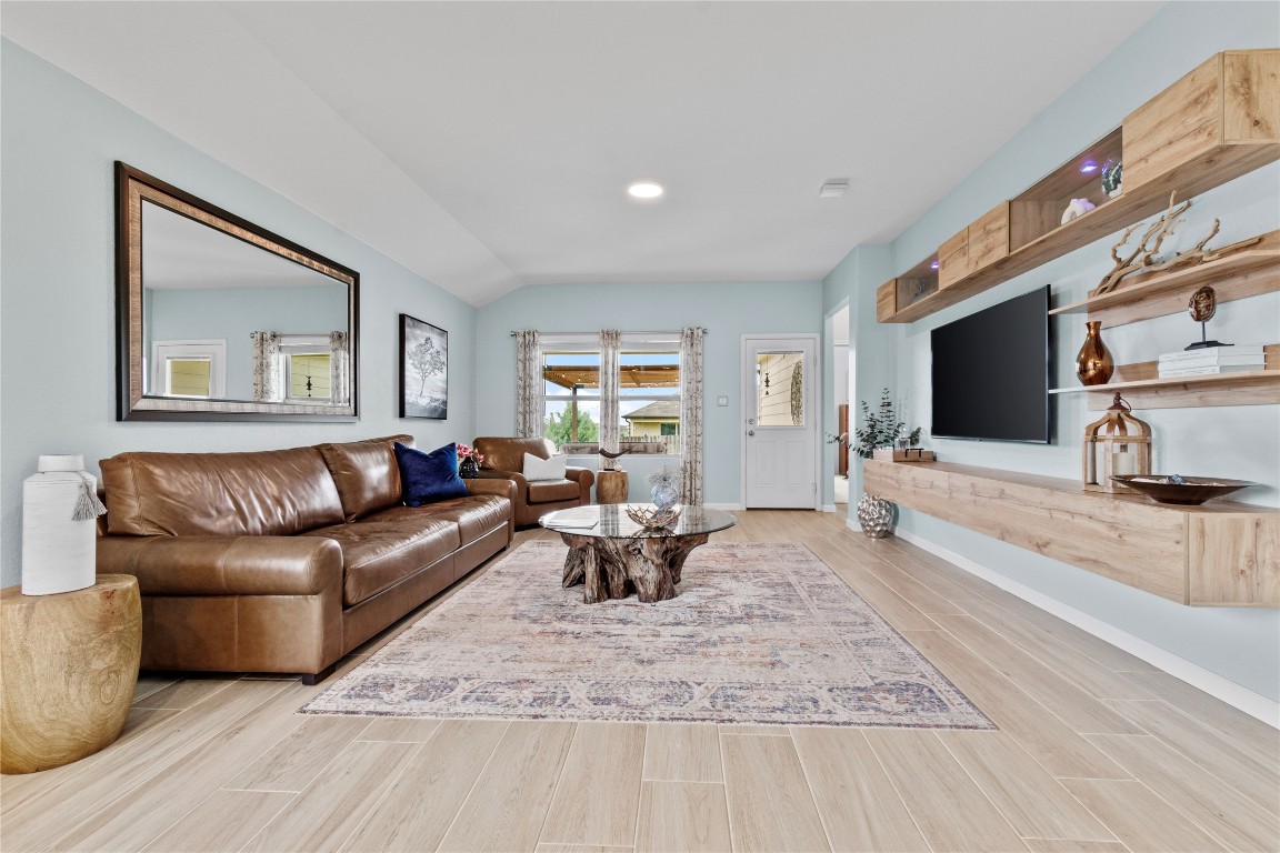 a living room with furniture wooden floor and a flat screen tv