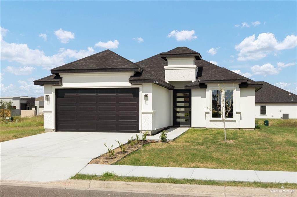 a front view of a house with a yard and garage