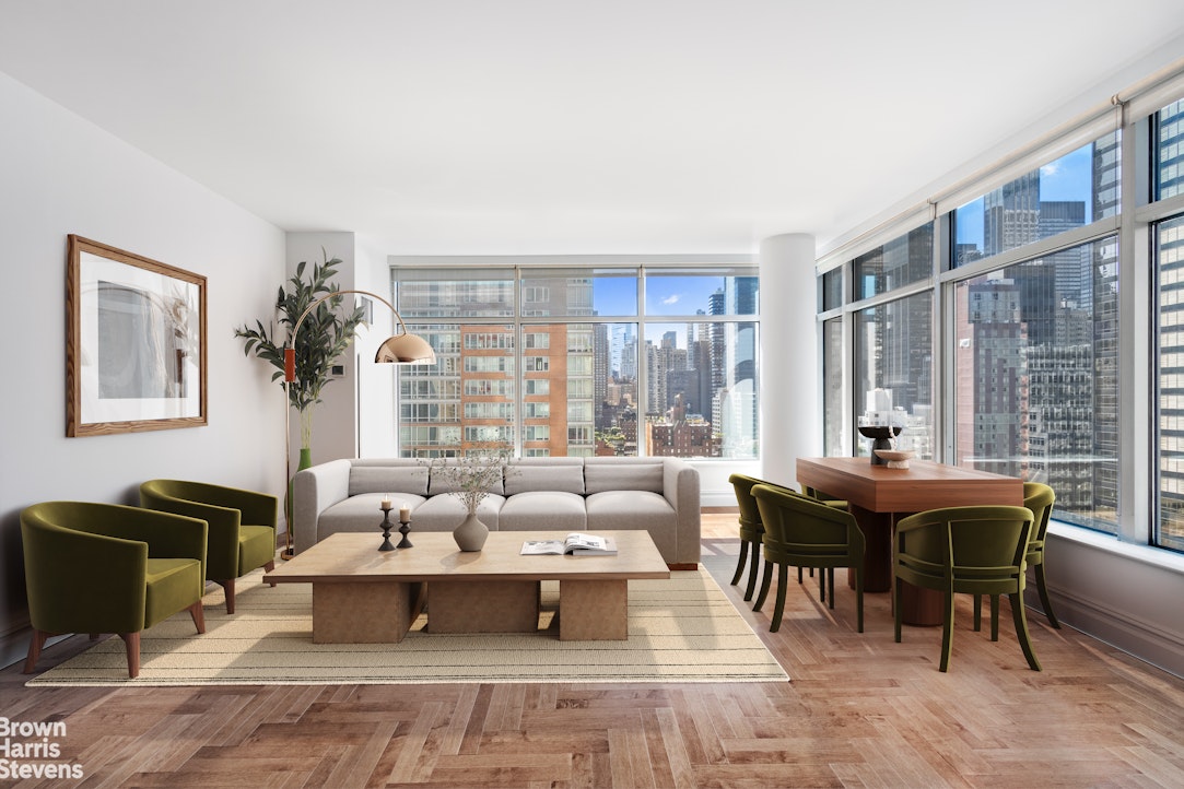 a living room with furniture two large windows and a dining table