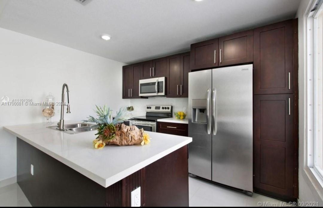 a kitchen with refrigerator and a sink