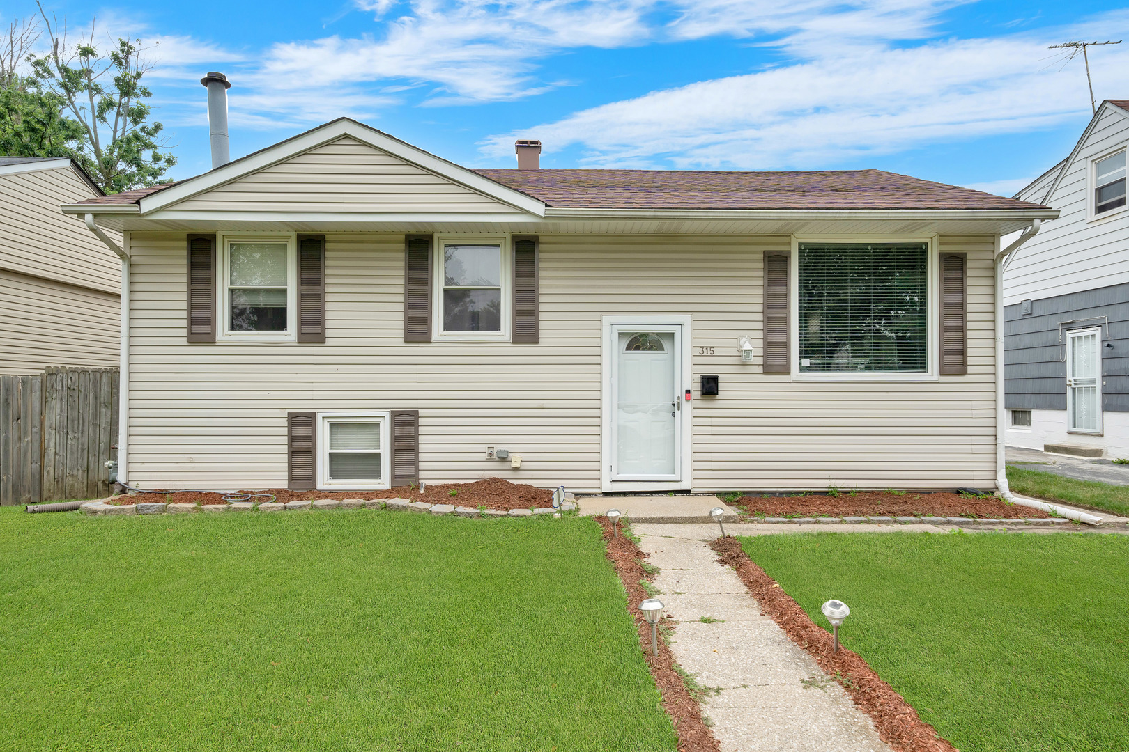 a front view of a house with a garden