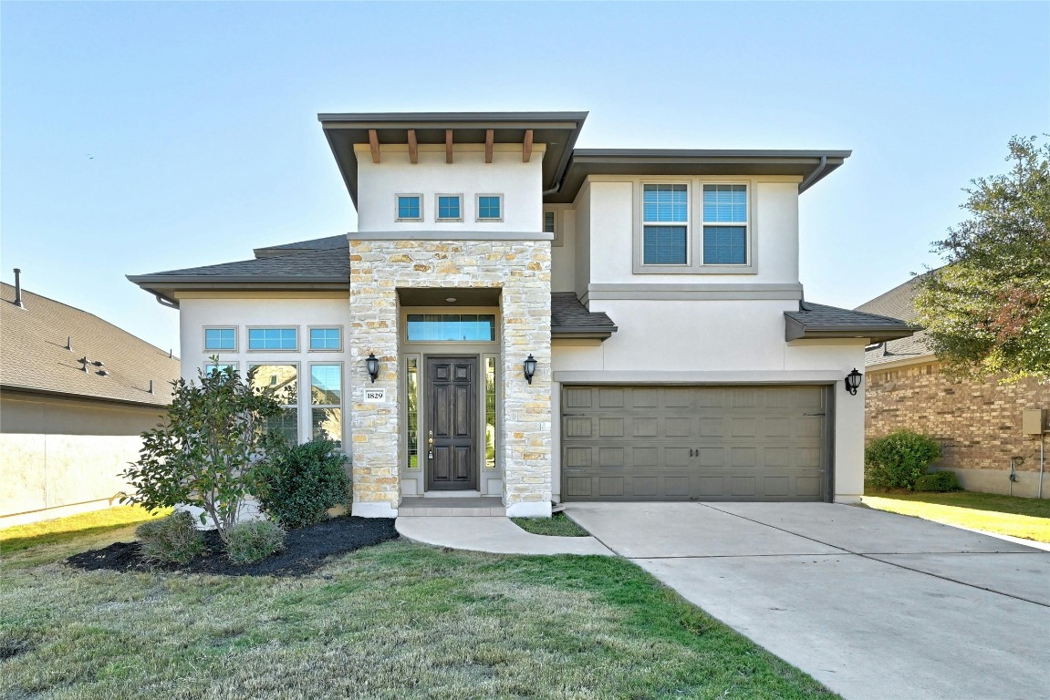 a front view of a house with a yard and garage